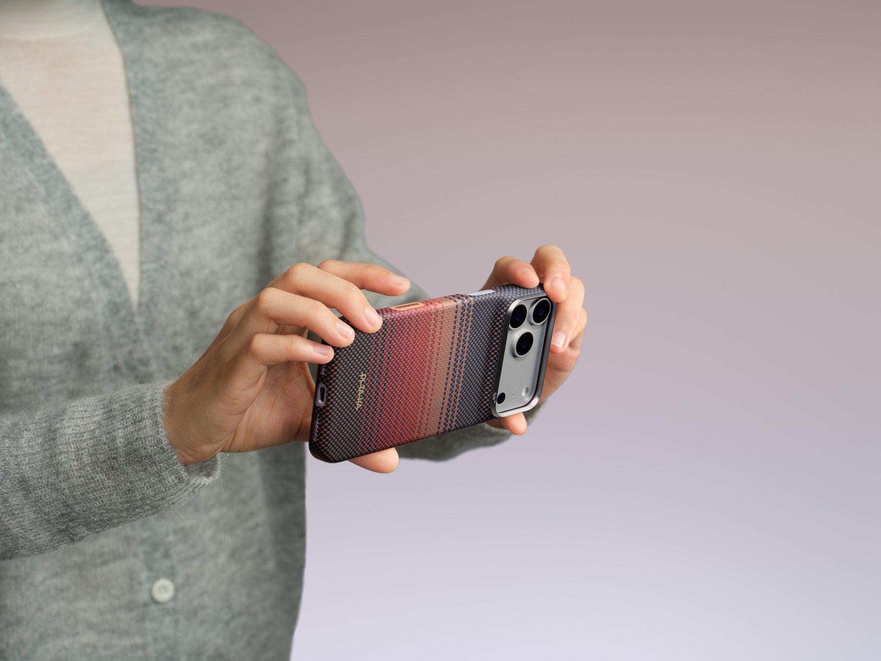 Hands holding an iPhone in a PITAKA aramid case