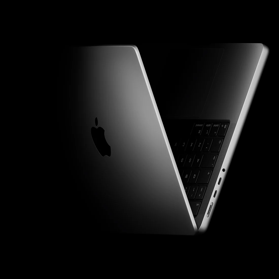 MacBook Pro, half open, catching the light.